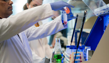 Scenes from the Shetty lab, with two students mixing two solutions into a centrifuge.