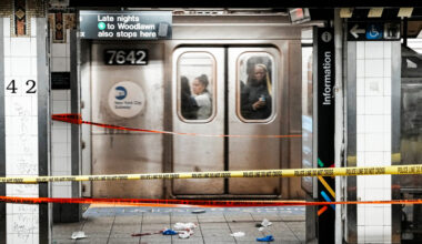 Commuters in a train pass near the crime scene where three people were attacked inside the subway system at Grand Central ...