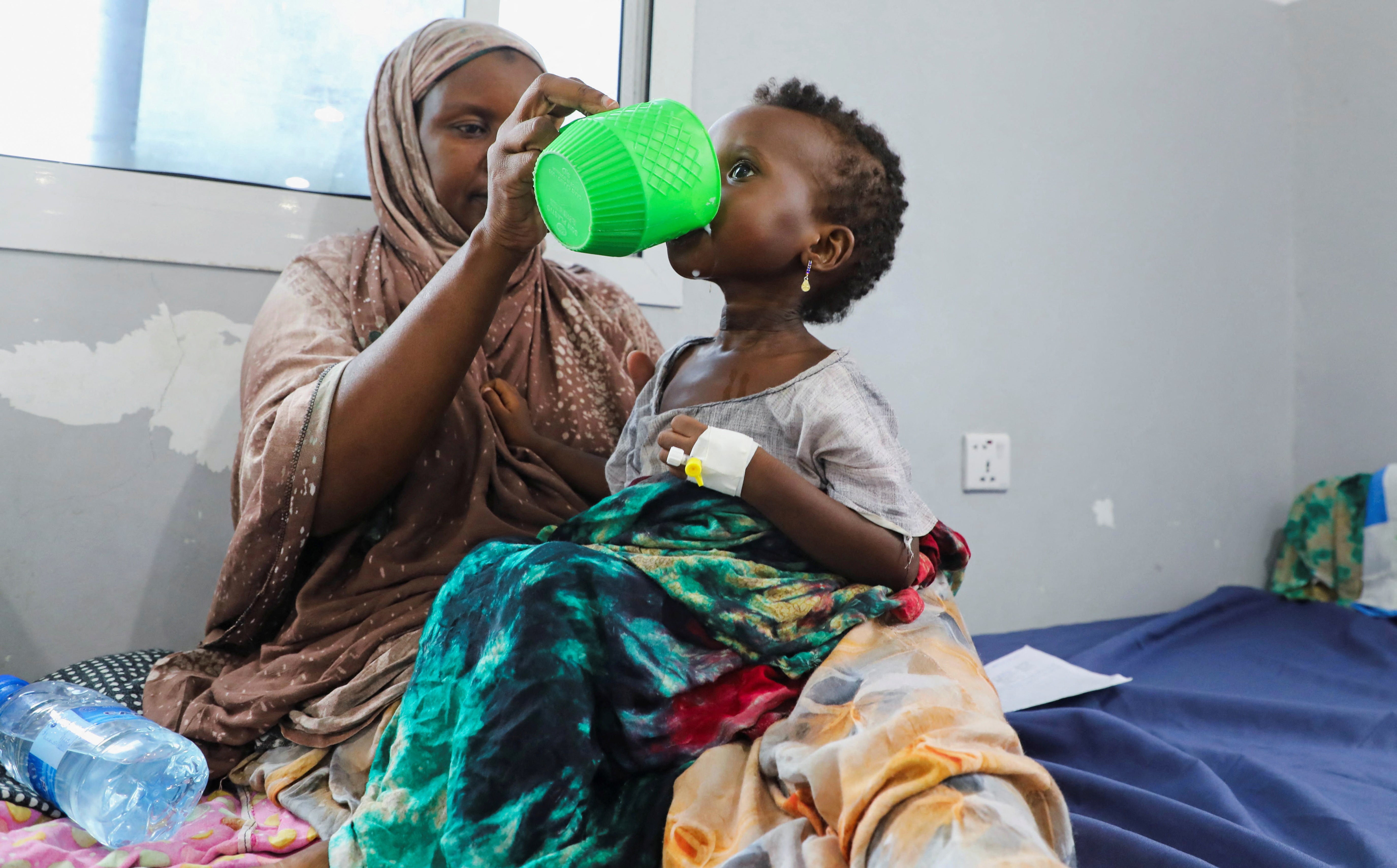 An internally displaced Somali woman feeds her malnourished child at the Daynile hospital amid shortages of lifesaving therapeutic foods