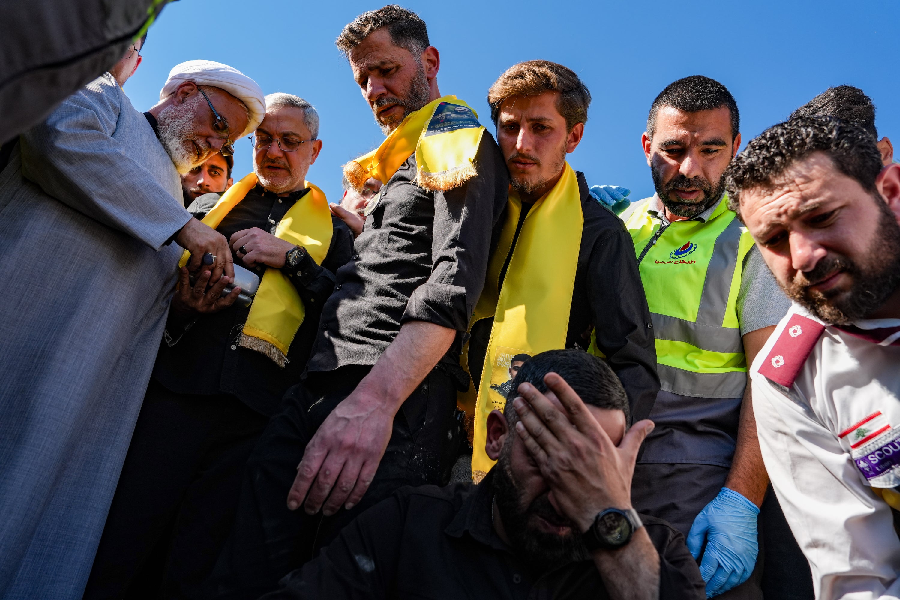 Men look upon the casket of a Hezbollah fighter that was killed by an Israeli strike last week while it is lowered into a grave during a funeral on 22 April 2026 in Tyre, Lebanon