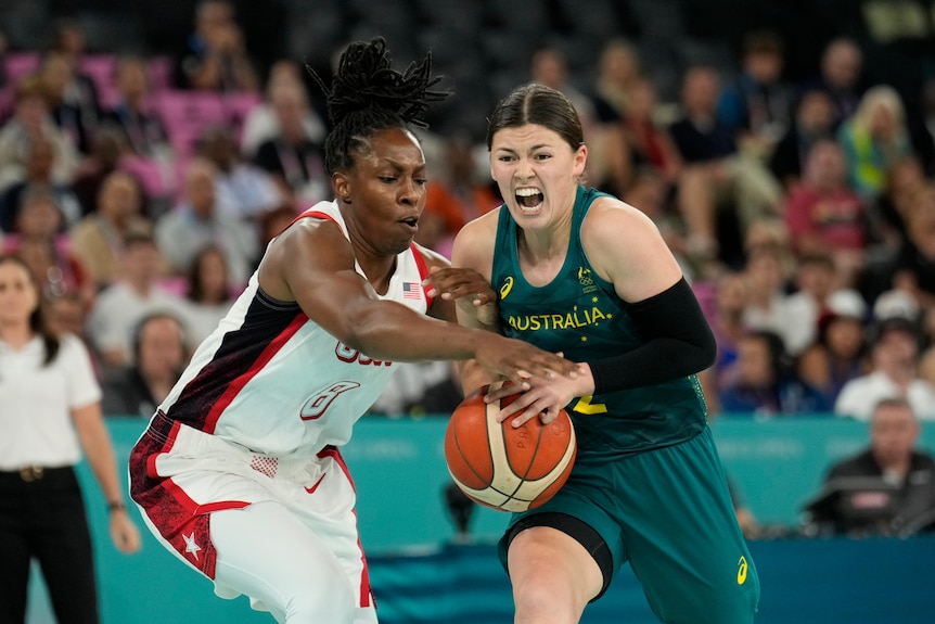 Jade Melbourne yells as she tries to carry the ball away from an opponent
