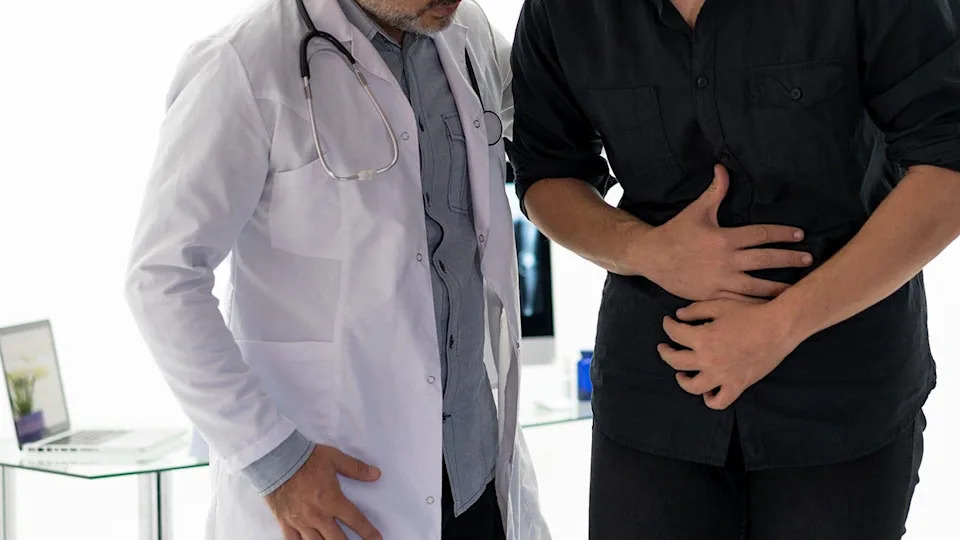 Doctor examining abdomen of patient in medical setting