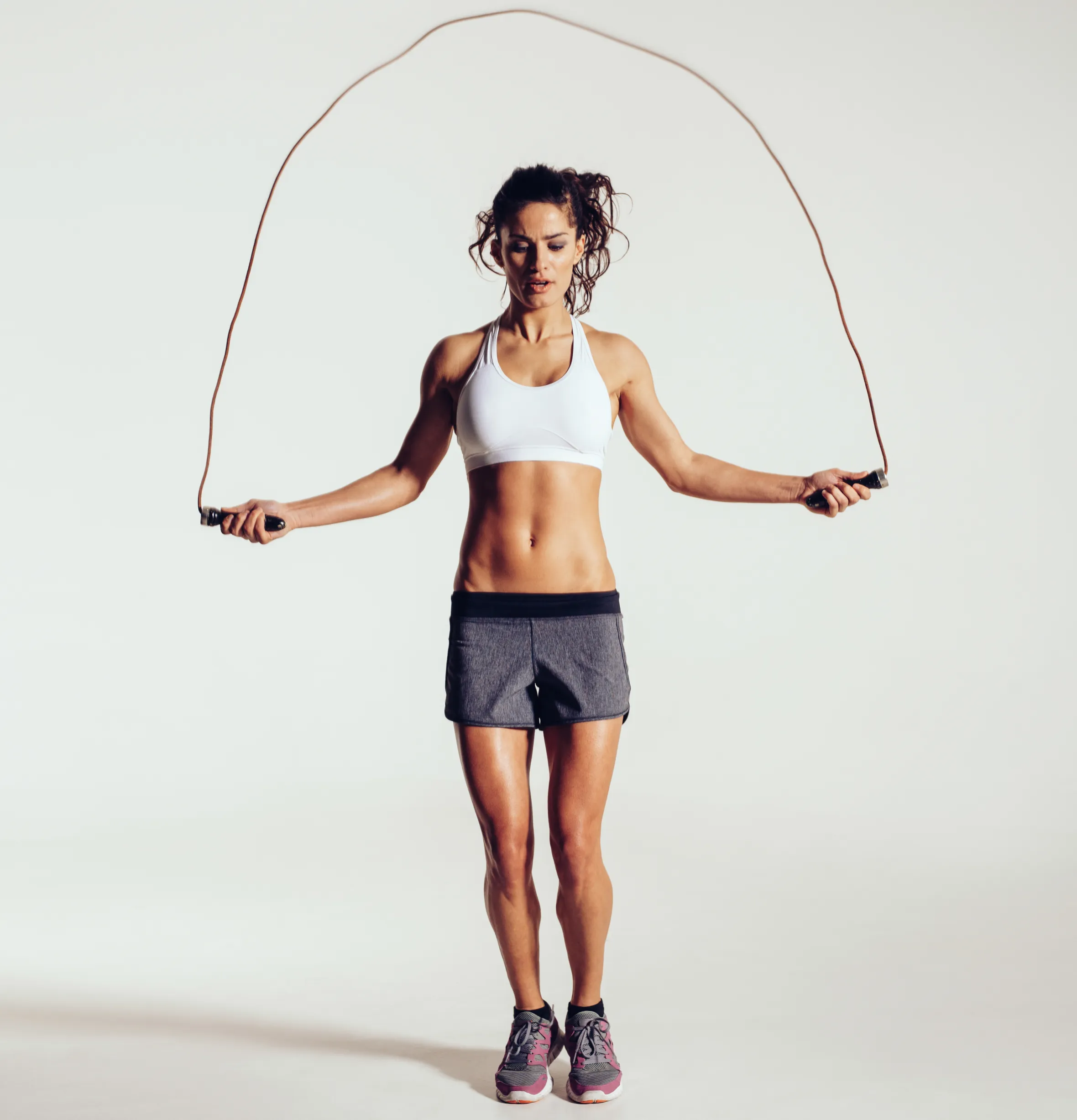 A fit young woman skipping rope.