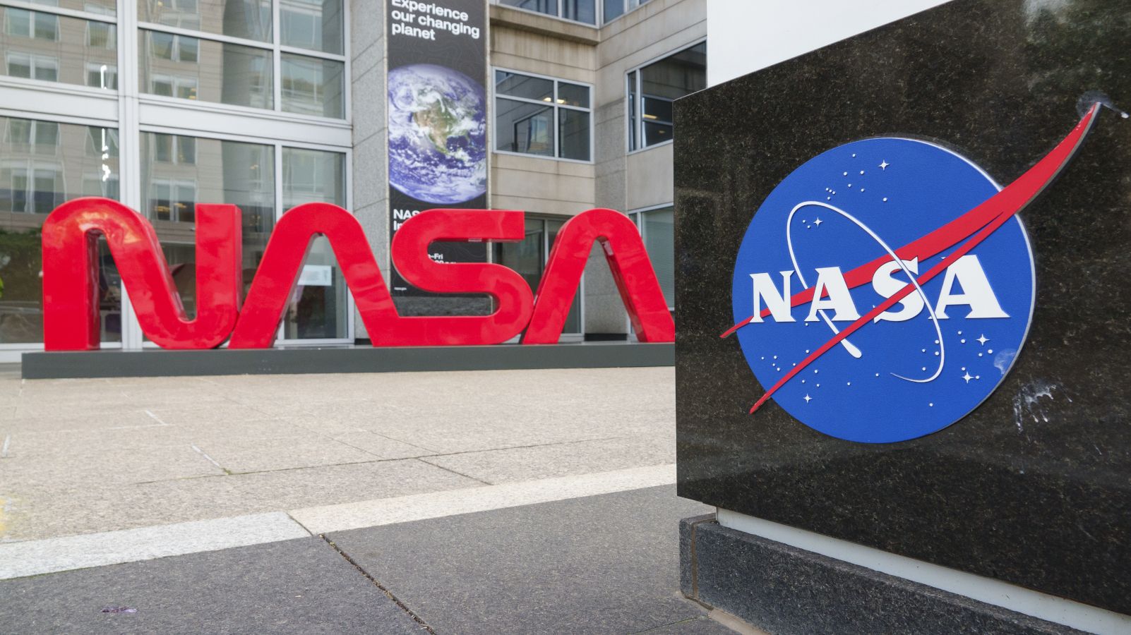 Large red letters spelling out NASA as a logo with a blue NASA icon nearby at the agency's headquarters.