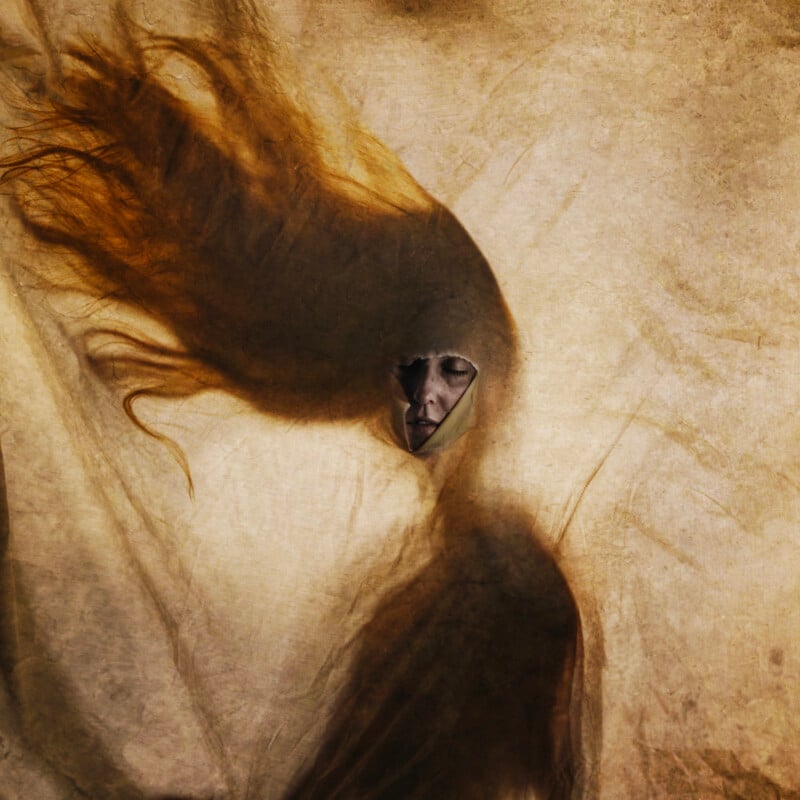 A surreal figure with flowing hair and a shadowy body blends into a textured, sepia-toned background. The head has a triangular opening revealing a solemn, partially hidden human face inside.