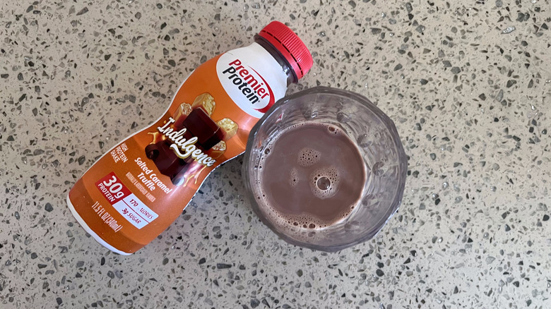 Indulgence Salted Caramel Truffle bottle with a glass cup