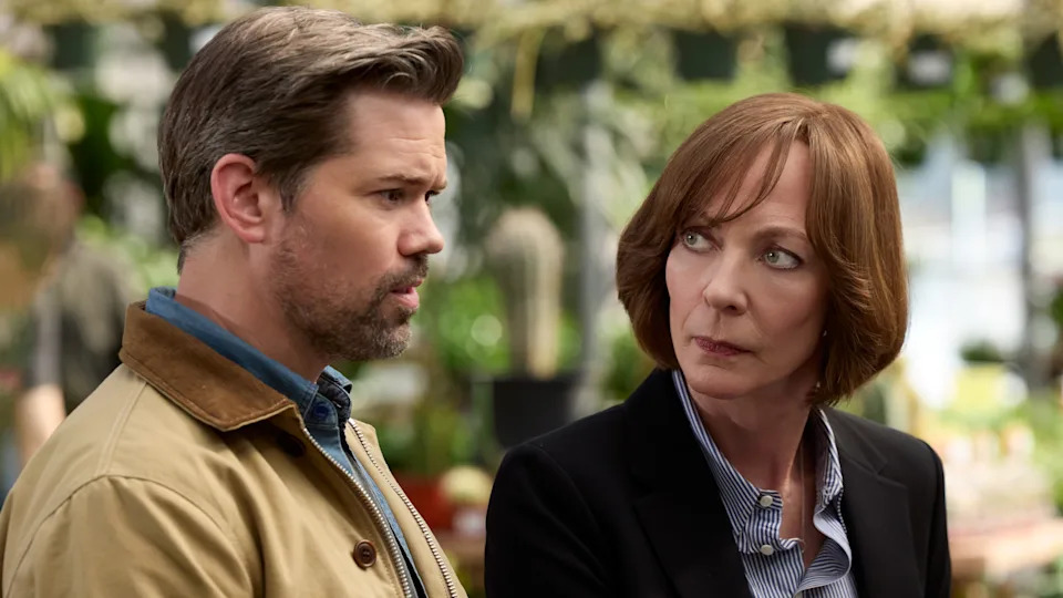 L-R: Andrew Rannells and Allison Janney sit together outdoors in a scene from
