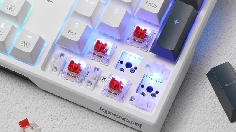 A Redragon K668 RGB Gaming Keyboard with several key caps and switches removed.