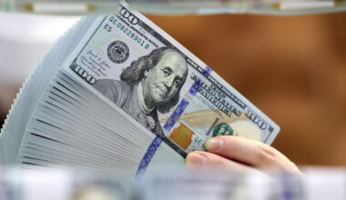An employee holds up dollar bills at Hana Bank