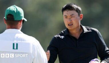 Li Haotong fist-bumps his caddie at the 2026 Masters