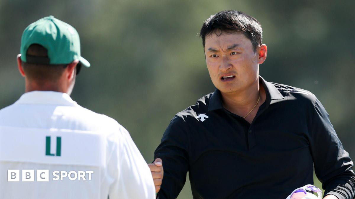 Li Haotong fist-bumps his caddie at the 2026 Masters