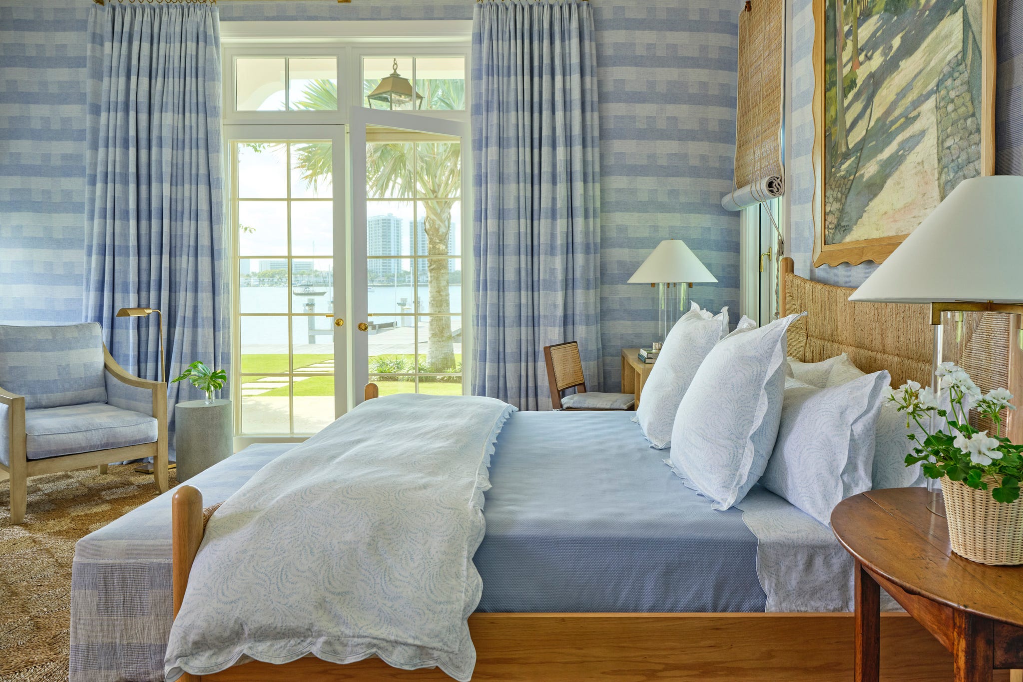 bedroom with large windows and a blue and white patterned wallpaper and curtains