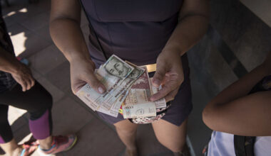 A woman receives Colombian pesos in exchange for Venezuelan bolivars after the reopening of the borders in Cúcuta, Colombia, on Tuesday, December 20, 2016.