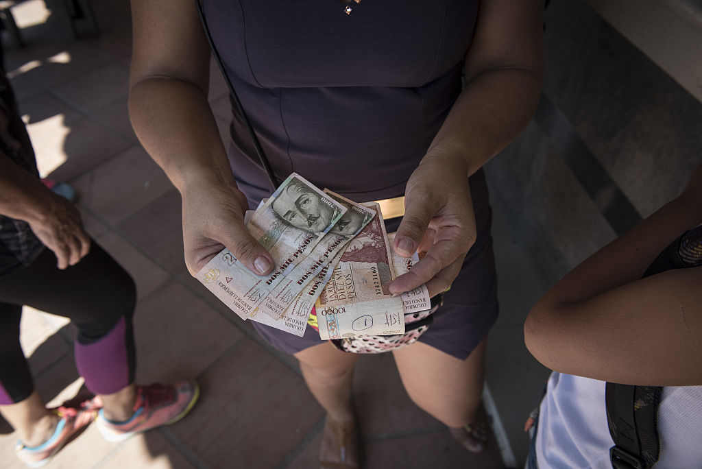 A woman receives Colombian pesos in exchange for Venezuelan bolivars after the reopening of the borders in Cúcuta, Colombia, on Tuesday, December 20, 2016.