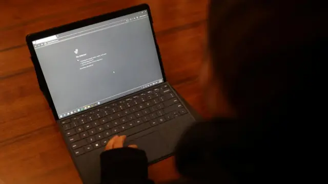 An Internet error is displayed on a laptop placed on a timber table.