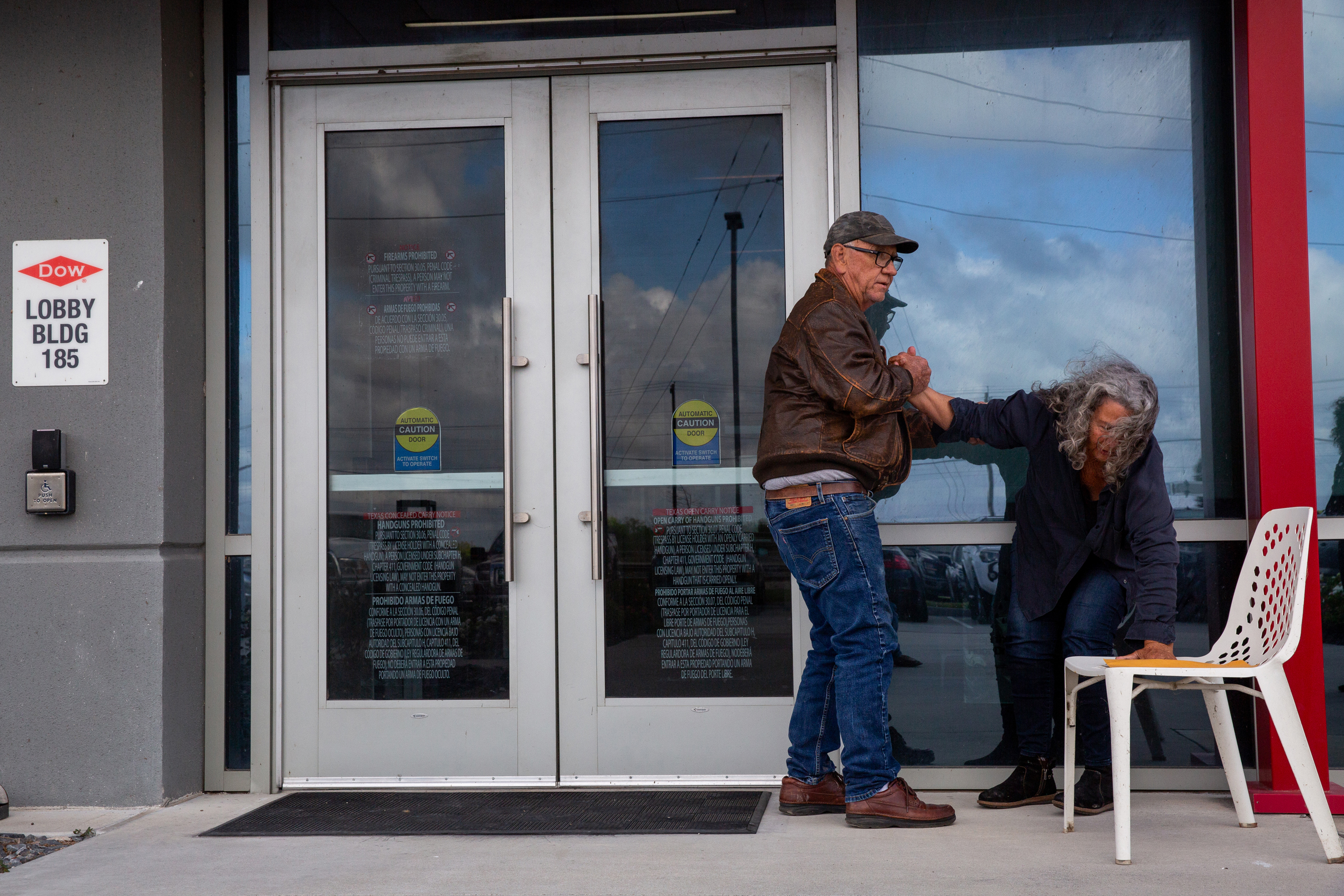 John Daniel helps Diane Wilson into a chair as she waits outside the Dow office doors to deliver her demands after 25 days on hunger strike on March 26.