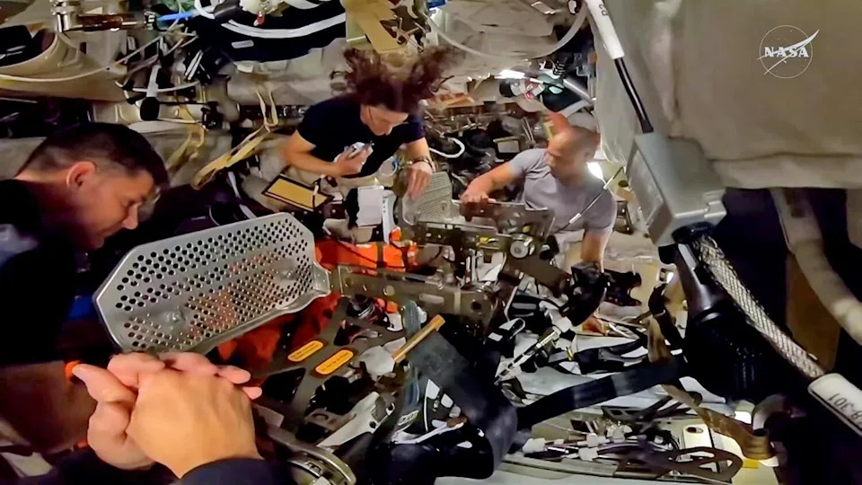 The astronauts re-install seats in their Orion capsule before donning their pressure suits to rehearse procedures they'll use when returning to Earth April 10. / Credit: NASA