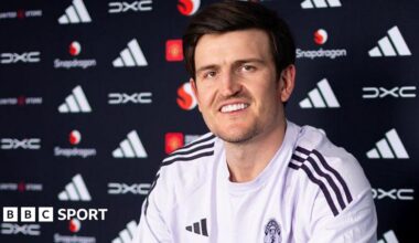 Harry Maguire smiling in a Manchester United news conference