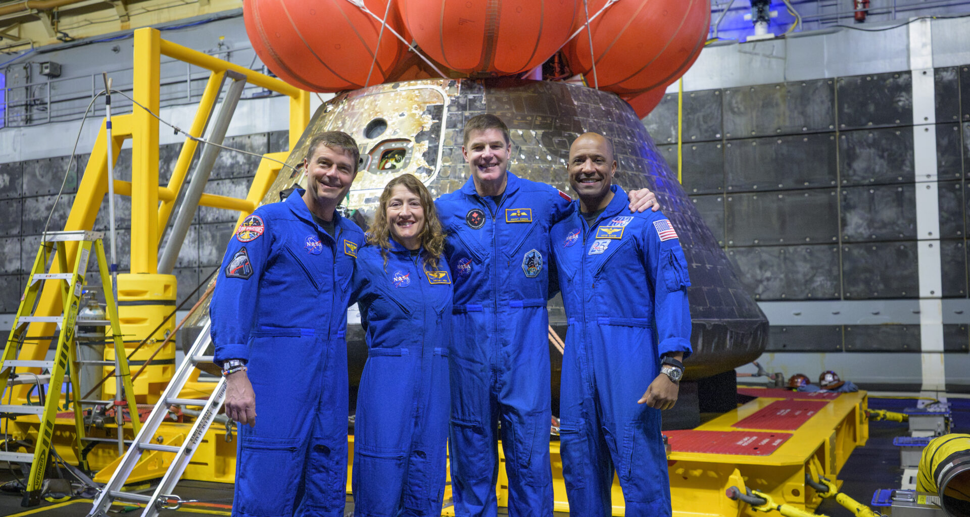 NASA astronauts Reid Wiseman, commander; left, Christina Koch, mission specialist; CSA (Canadian Space Agency) astronaut Jeremy Hansen, mission specialist; and NASA astronaut Victor Glover, Artemis II pilot, right, pose for a group photo after viewing the Orion spacecraft in the well deck of USS John P. Murtha, Saturday, April 11, 2026, in the Pacific Ocean off the coast of California. The quartet splashed down Friday, April 10 at 5:07 p.m. PDT (8:07p.m. EDT).