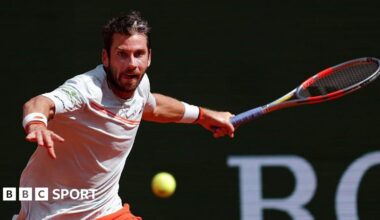 Cameron Norrie, in largely white T-shirt with orange trim, plays a forehand at the Monte Carlo Masters on Sunday