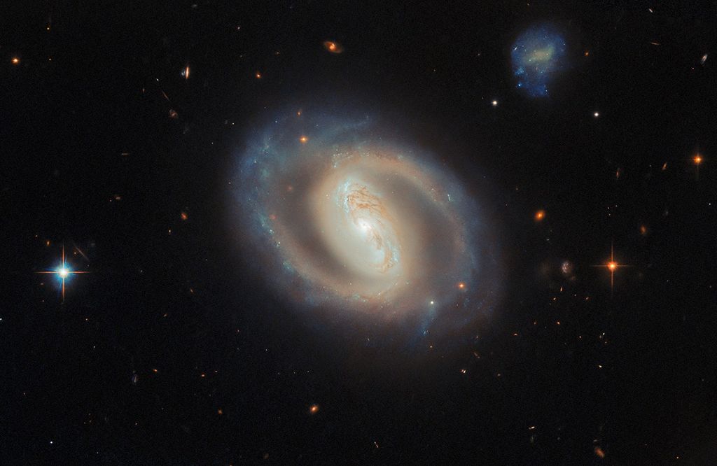barred spiral galaxy glowing with a bright core, surrounded by dusty rings and scattered stars in deep space.