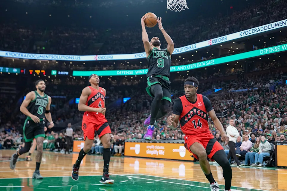 Apr 5, 2026; Boston, Massachusetts, USA; Boston Celtics guard Derrick White (9) shoots a layup against Toronto Raptors guard Ja'Kobe Walter (14) during the first half at TD Garden. Mandatory Credit: Gregory Fisher-Imagn Images
