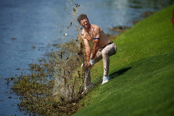 No shirt, no-good shot. Brennan tried to hit the ball out of the shallow water, but it dropped back in the drink.