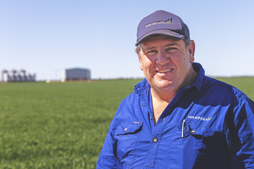 a man wearing blue looks at the camera