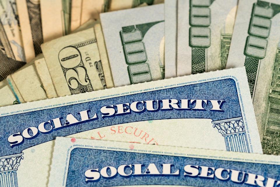 Two Social Security cards on a pile of cash.
