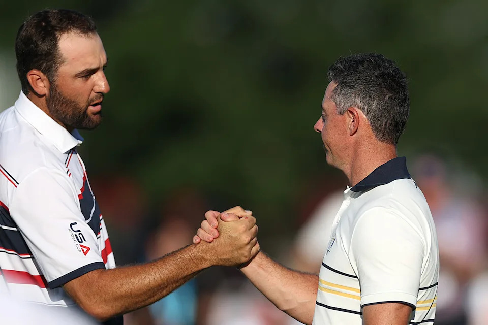 Rory McIlroy and Scottie Scheffler shaking hands on the green after the conclusion of their singles match at the 2025 Ryder Cup