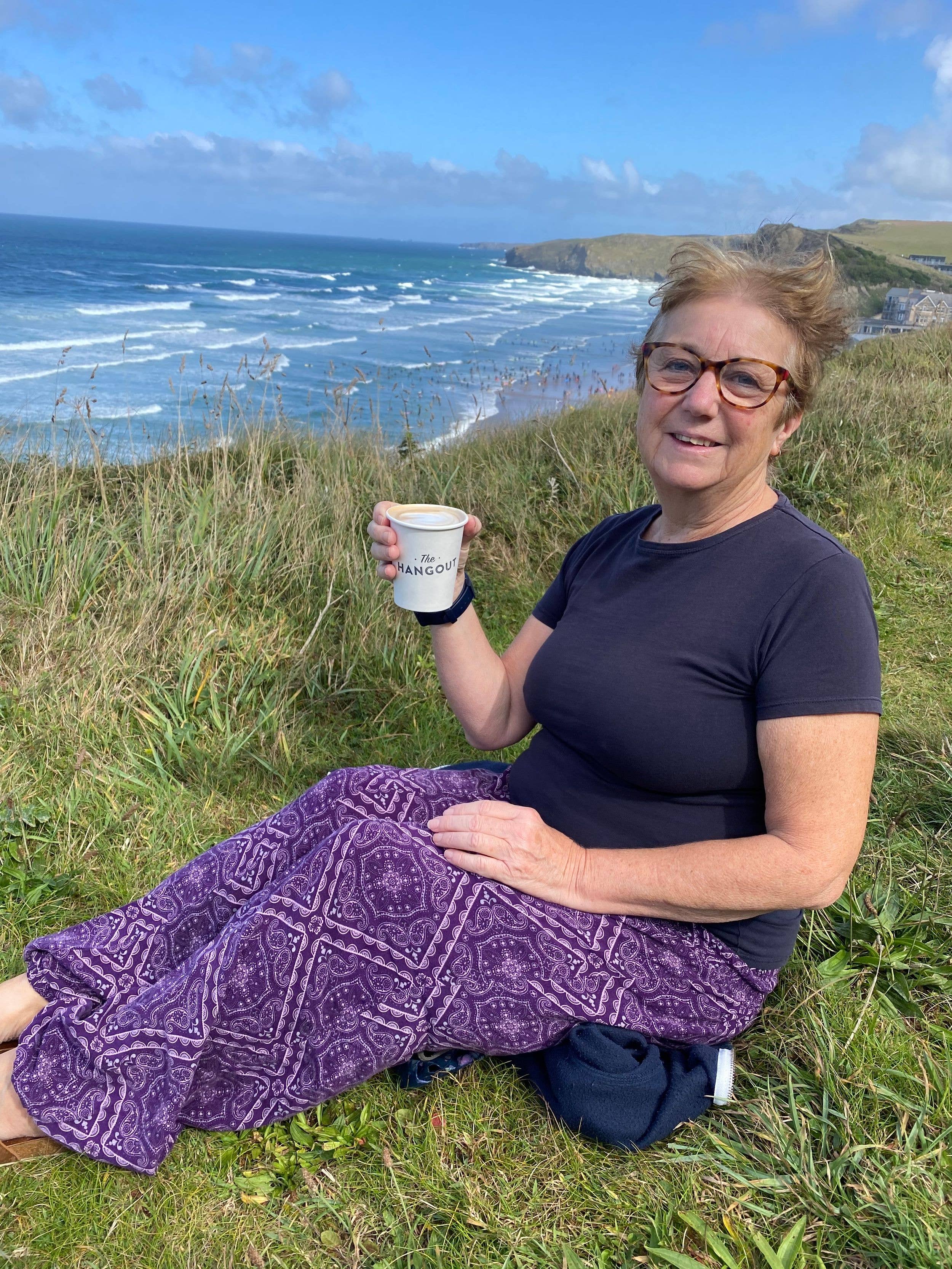 Woman drinking coffee on a coastal walk 