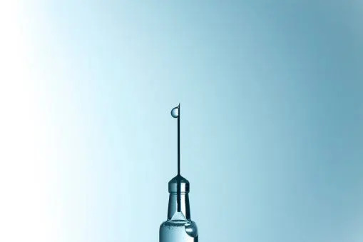 a drop of medicine on a needle