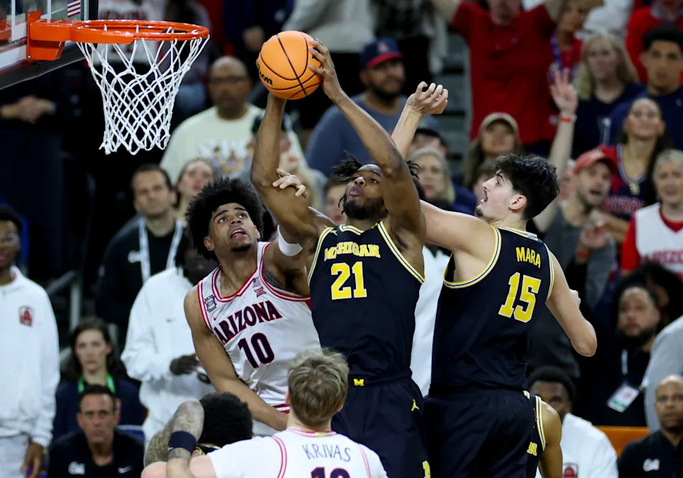 Apr 4, 2026; Indianapolis, IN, USA; Michigan Wolverines forward Morez Johnson Jr. (21) rebounds the ball against Arizona Wildcats forward Koa Peat (10) in the second half during a semifinal of the Final Four of the men's 2026 NCAA Tournament at Lucas Oil Stadium. Mandatory Credit: Trevor Ruszkowski-Imagn Images