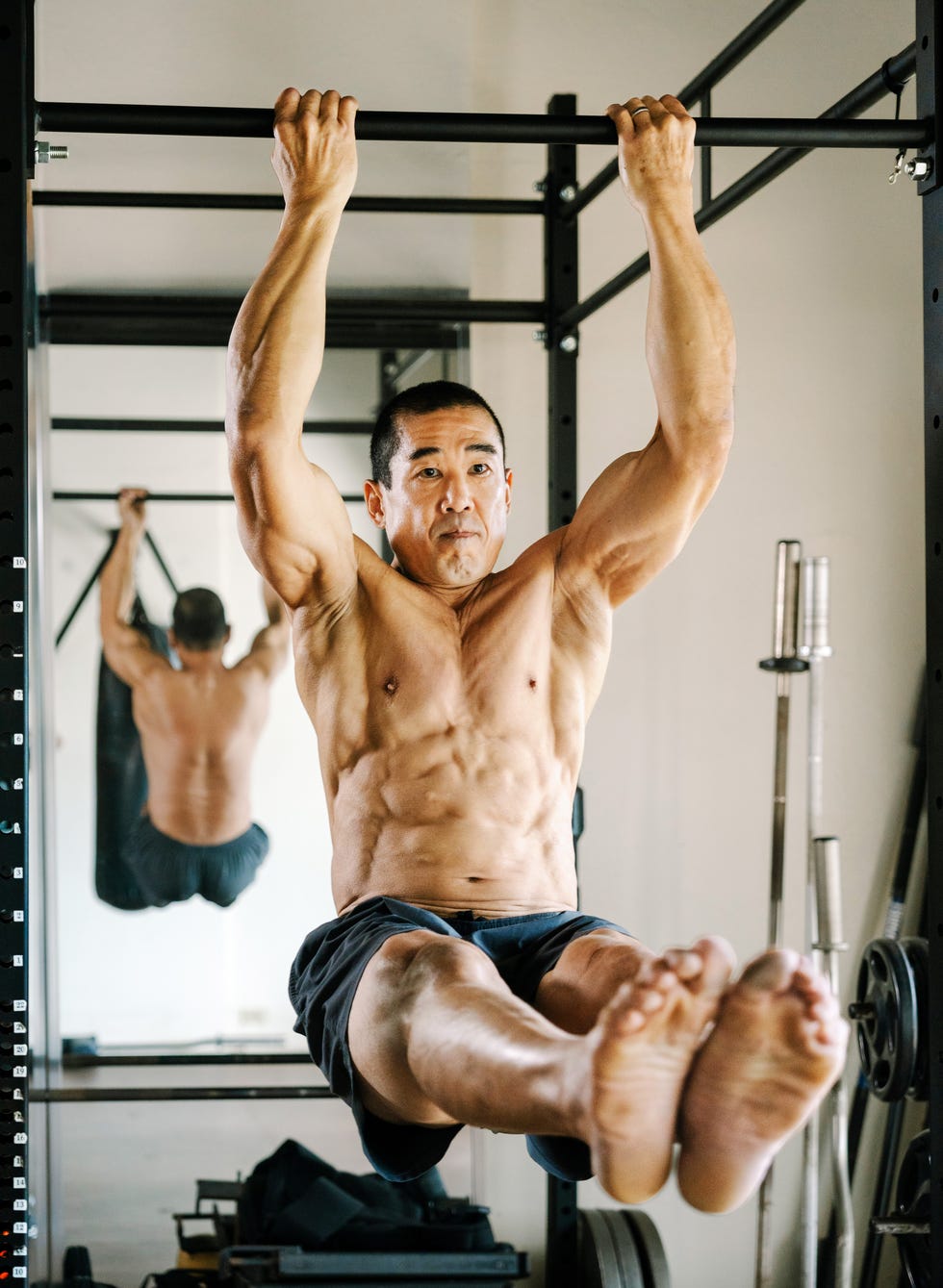 Person performing a hanging exercise in a gym. Person performing a hanging exercise in a gym.