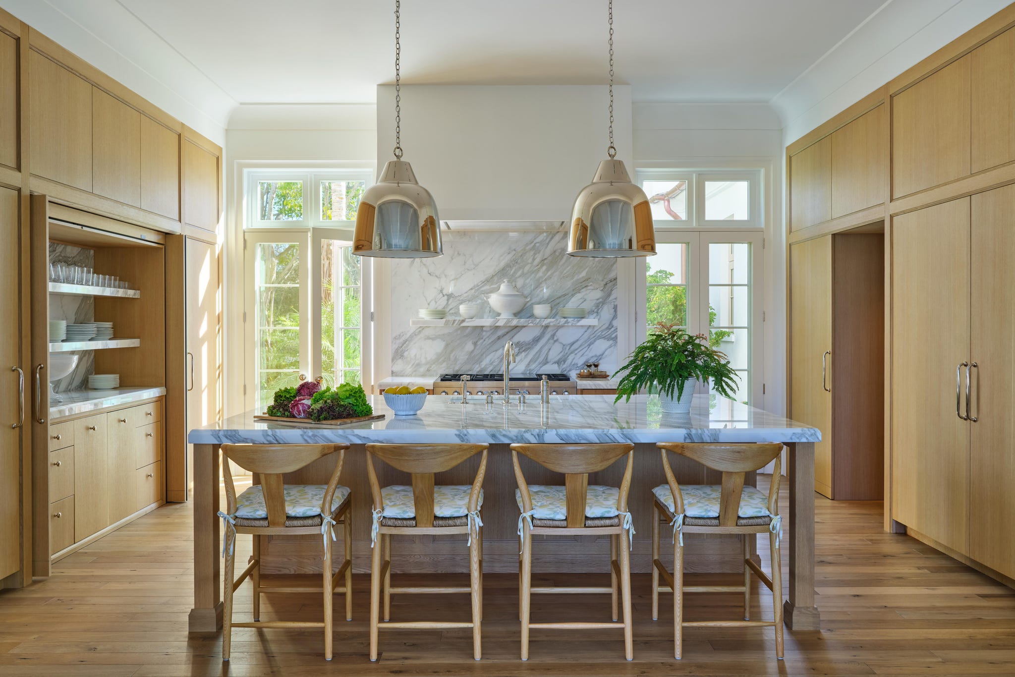 Modern kitchen with a marble island and wooden cabinets.