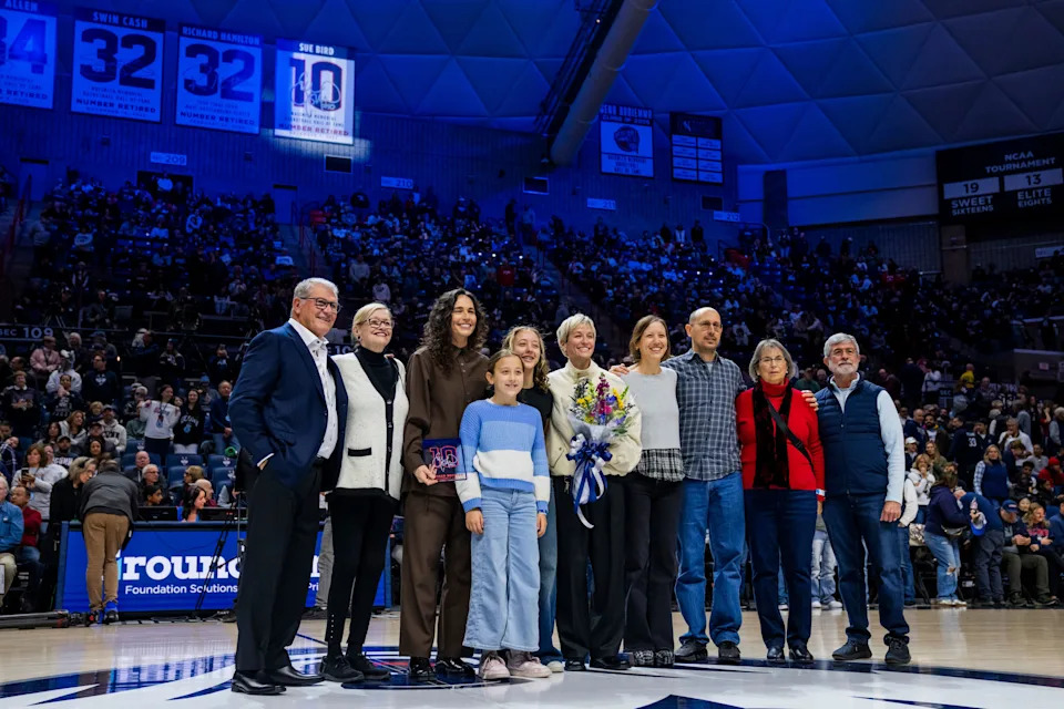 Sue Bird poses with Connecticut Huskies head coach Geno Auriemma, family, and partner Megan Rapinoe during a jersey retirement ceremony in Storrs, Connecticut.