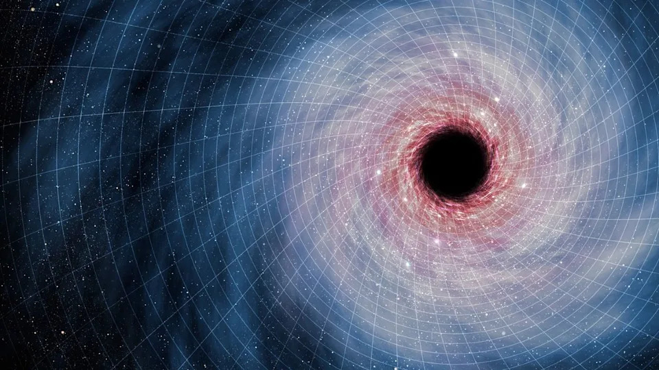  A swirl of blue and red light around a dark black hole in the right side of the image sits on a white grid of blocks showing the fabric of spacetime. 