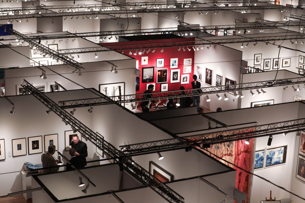 A crowded VIP preview at The Photography Show at the Park Avenue Armory, with collectors and visitors gathered among gallery booths under a high industrial ceiling