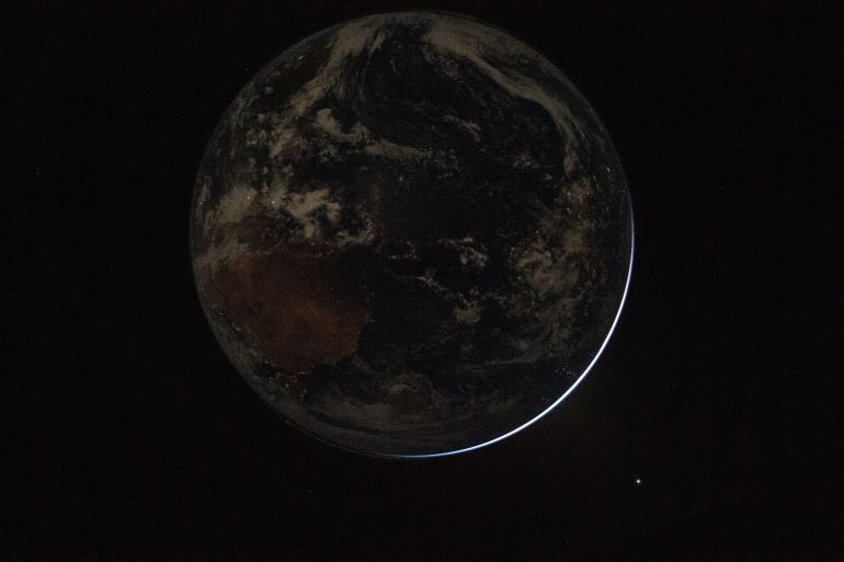 This handout picture provided by NASA shows a view of a backlit Earth as seen through the Orion spacecrafts window