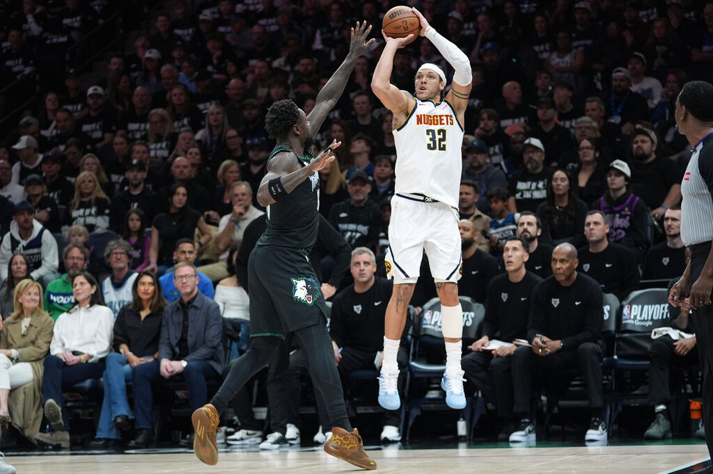 Denver Nuggets forward Aaron Gordon (32) goes up to shoot over Minnesota Timberwolves forward Julius Randle, center left, during the first half of Game 4 of a first-round NBA basketball playoff series, Saturday, April 25, 2026, in Minneapolis. (AP Photo/Abbie Parr)
