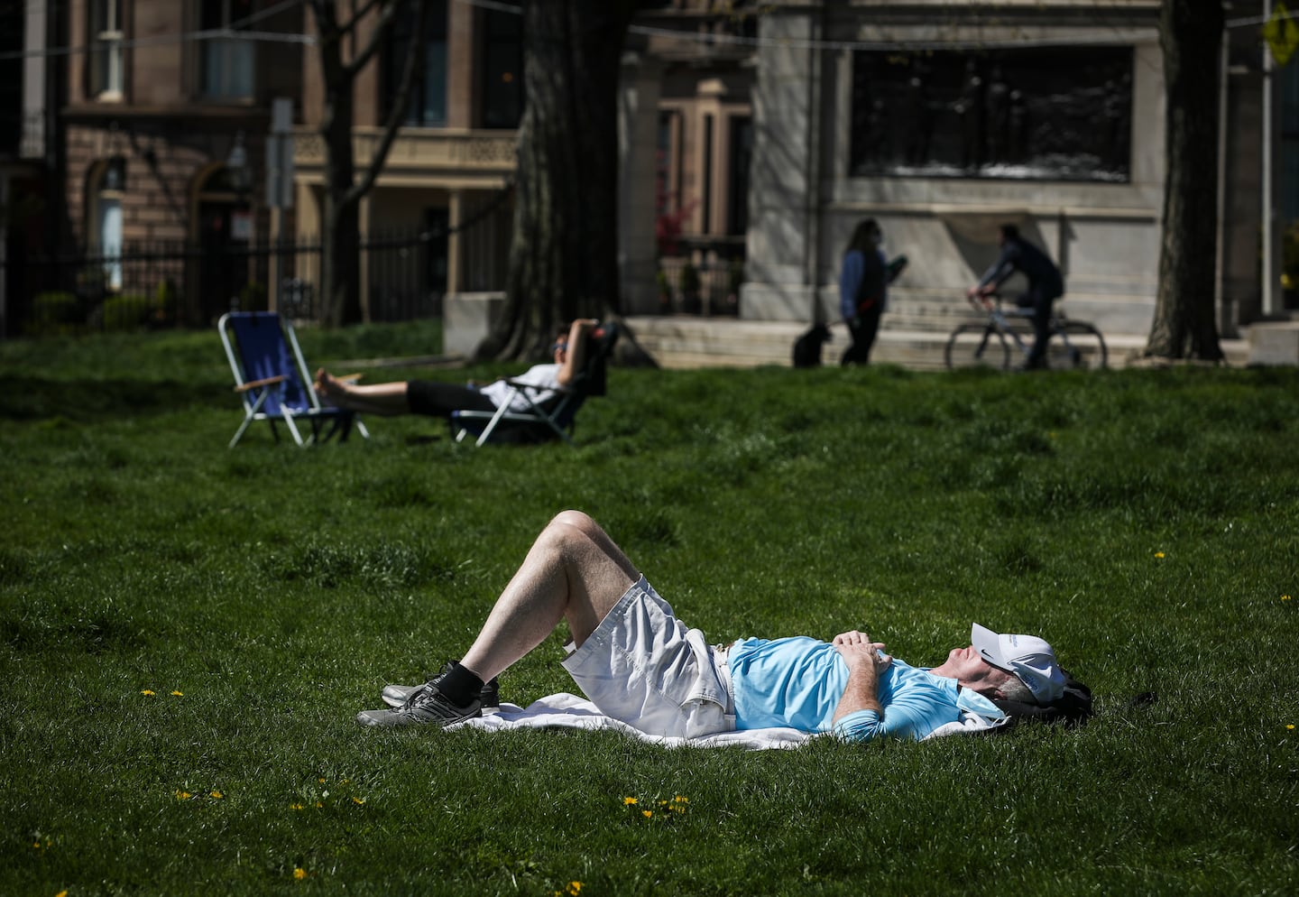 A man took a nap in the sun on Boston Common.