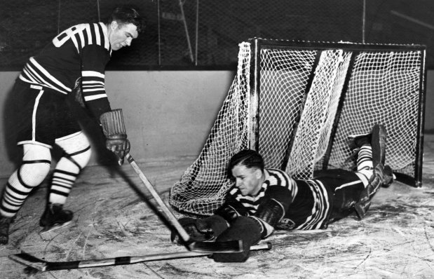 Charlie Gardiner was the franchise's first goalie and one of its three best. Arriving in 1927, one year after the Blackhawks came to Chicago, Gardiner played just seven seasons before a brain hemorrhage ended his life a couple of months after his spectacular play led Chicago to its first Stanley Cup in 1934. In eight playoff games that year, he allowed just 12 goals. Gardiner recorded 42 shutouts, was twice a Vezina Trophy winner and he had a goals against of average of 2.02. (Chicago Herald and Examiner) Original caption: Goalie Charlie Gardiner, veteran member of the Hawks, is shown lying flat on his face to stop the effort of Roger Jenkins to score, circa Nov. 10, 1932. The picture was taken while the team engaged in a strenuous practice session at the Coliseum before entraining last night for Detroit to meet the Red Wings tonight in the season opener. HOCKEY