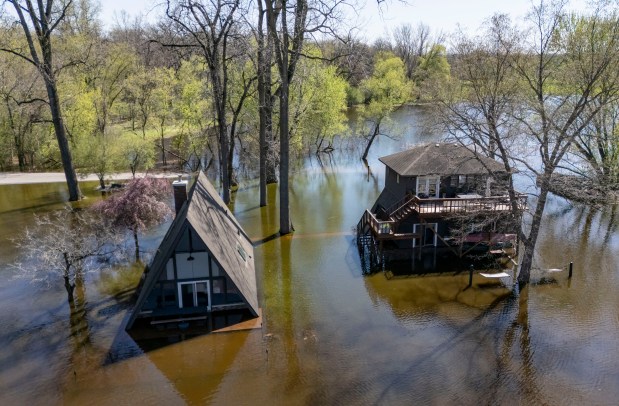 Houses along Whippoorwill Drive are flooded as the Fox River rises on April 20, 2026, in Crystal Lake. (Brian Cassella/Chicago Tribune)