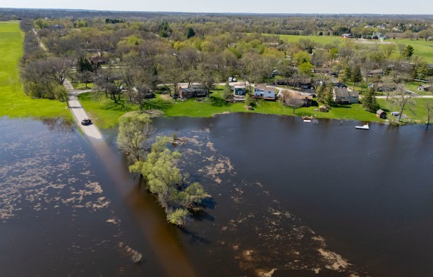 Whippoorwill Drive disappears beneath floodwaters as the Fox River rises on April 20, 2026, in Crystal Lake. (Brian Cassella/Chicago Tribune)