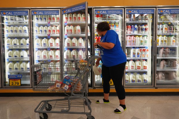 A shopper pulls a gallon of milk for purchase at a grocery store in Dallas, April 15, 2026. (LM Otero/AP)