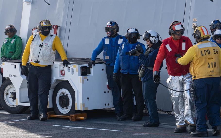 A sailor stands and looks at her camera.