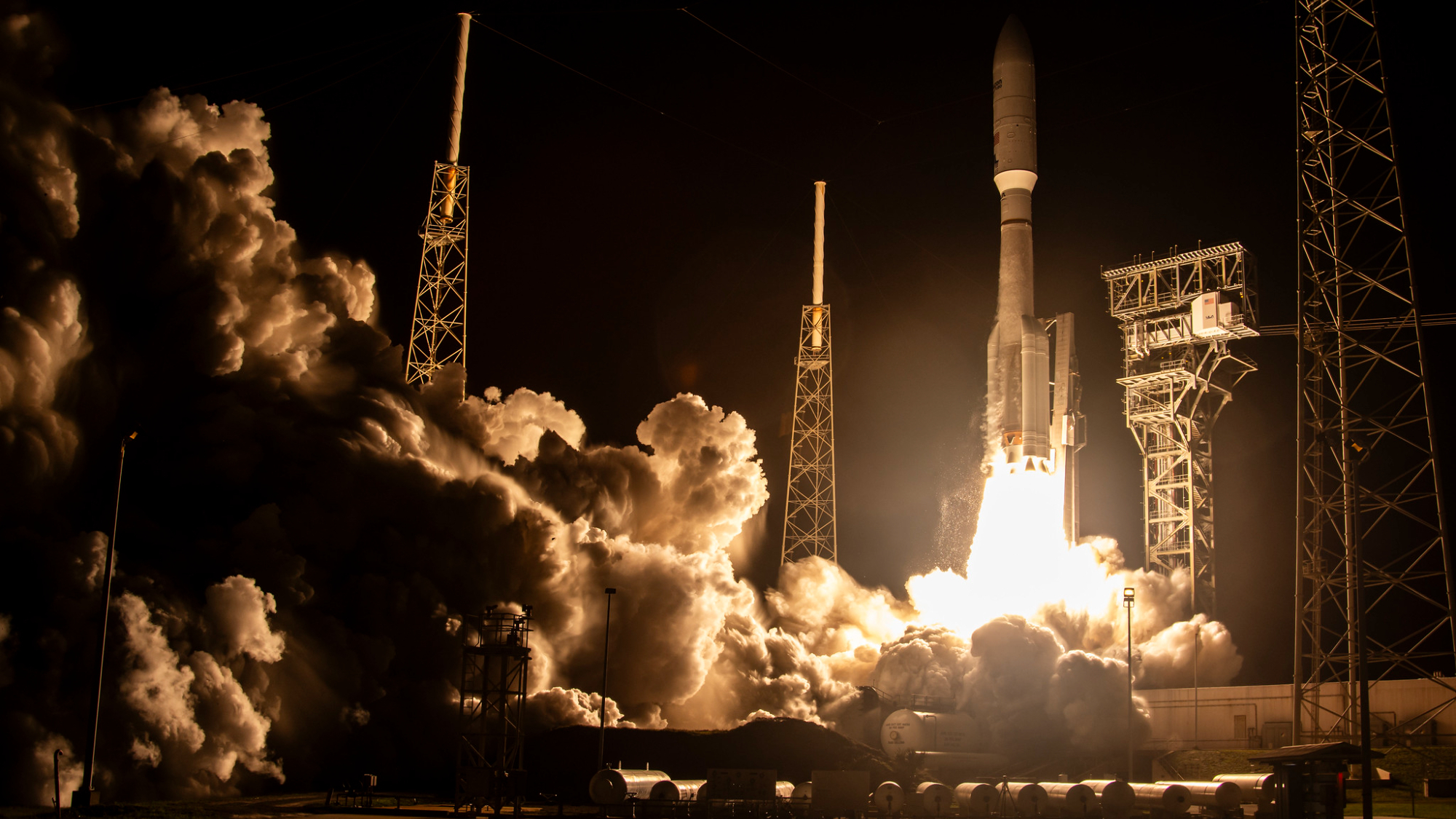 a big white rocket launches into a night sky