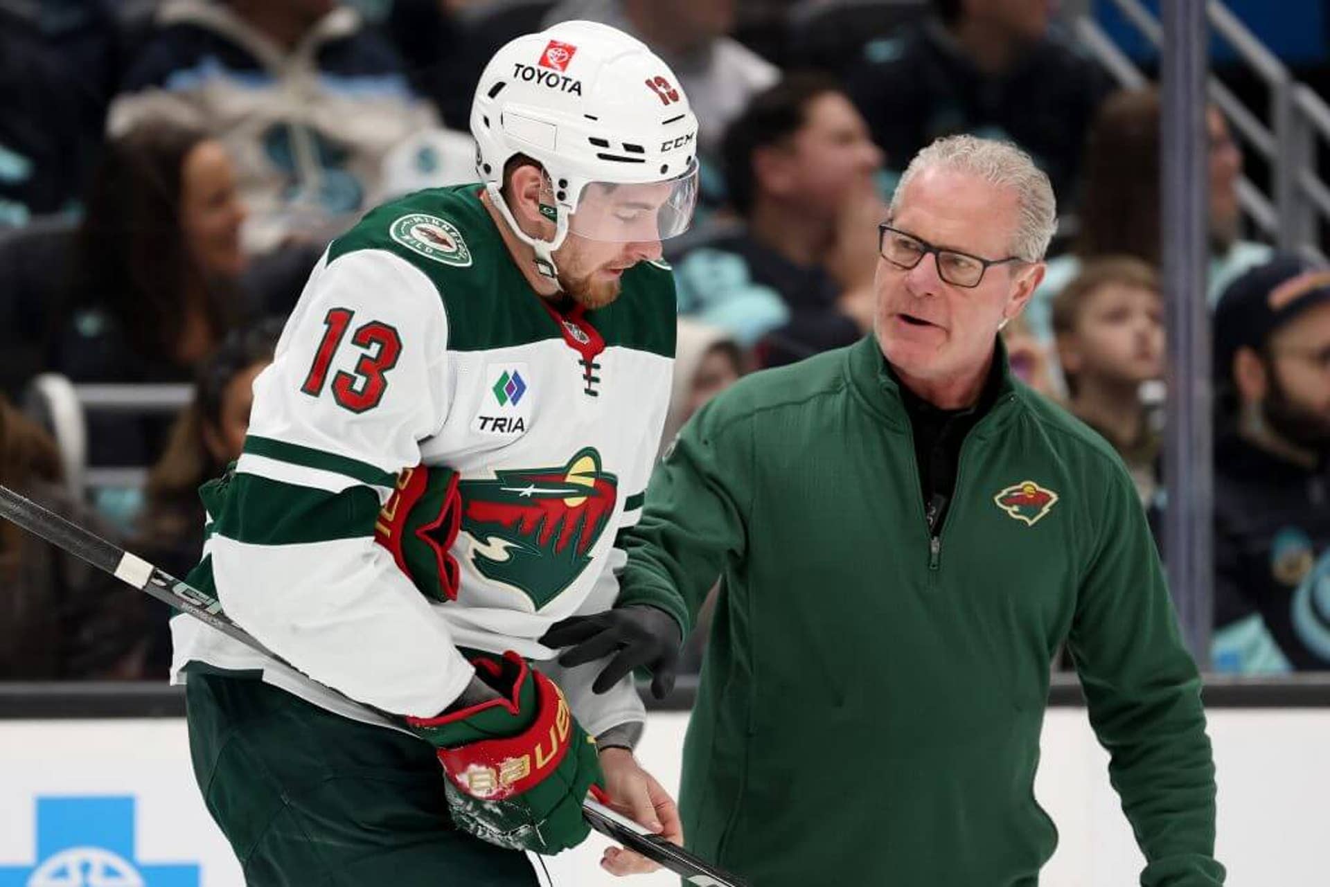 Yakov Trenin leaves the ice alongside a Minnesota Wild athletic trainer.