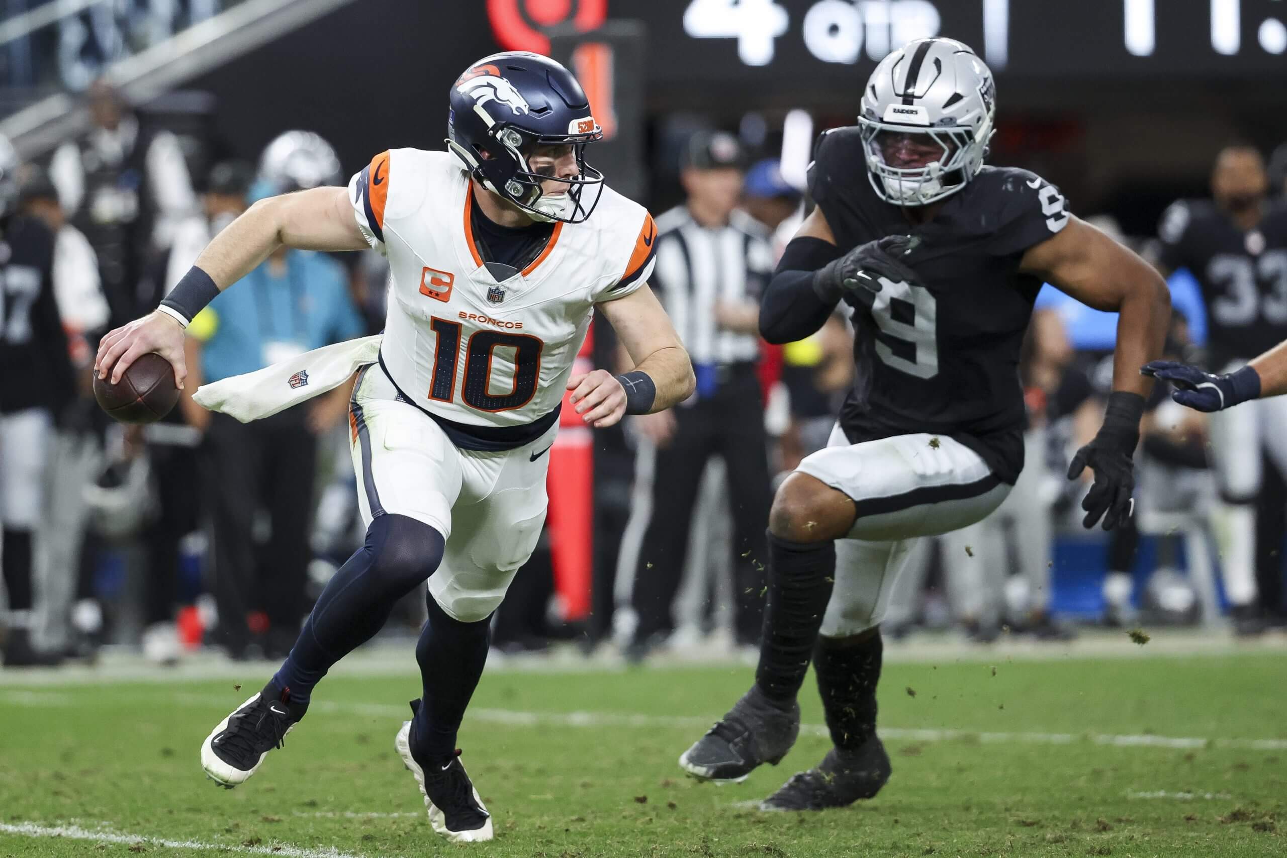Bo Nix #10 of the Denver Broncos is pressured by Tyree Wilson #9 of the Las Vegas Raiders