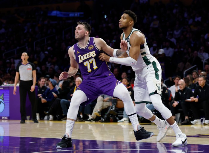 Giannis Antetokounmpo and Luka Doncic fight for position on the court.